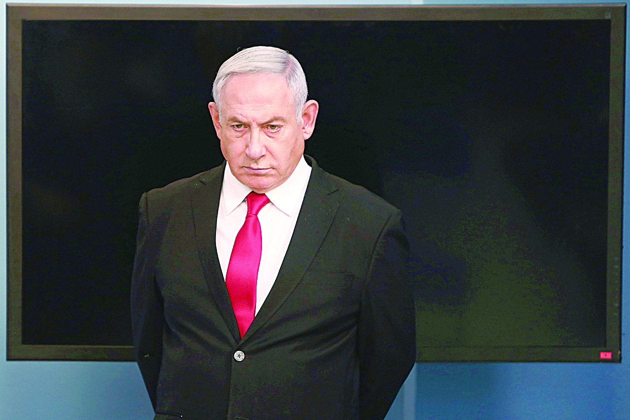 ne(FILES) In this file photo taken on March 14, 2020 Israeli Prime Minister Benjamin Netanyahu arrives for a speech at his Jerusalem office on new measures to fight the spread of Coronavirus in Israel. - Netanyahu and his close aides have been placed under quarantine after a staffer within his office tested positive for COVID-19, a statement and Israeli media said on March 30, 2020. The statement did not mention the positive test of a staffer, but multiple Israeli media outlets have reported the case, which was confirmed to AFP by separate sources. (Photo by GALI TIBBON / various sources / AFP)