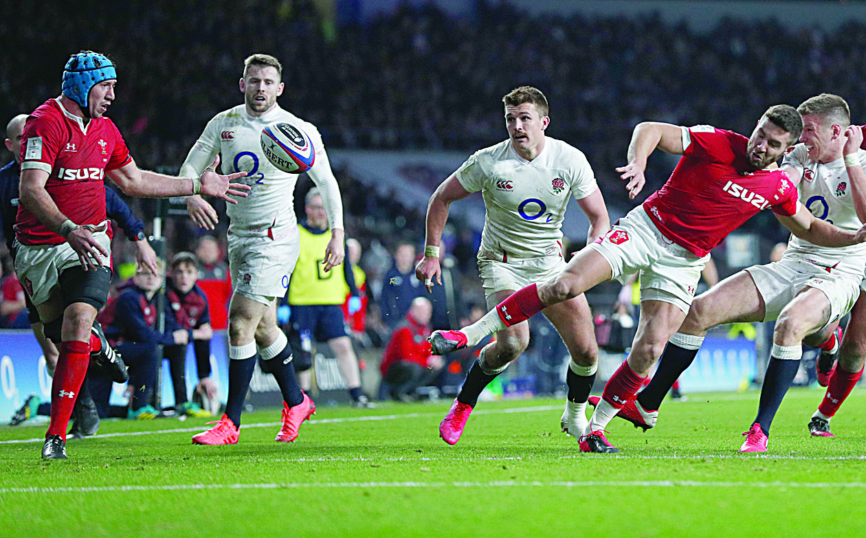 Wales' flanker Justin Tipuric (L) receives the ball to score a try during the Six Nations international rugby union match between England and Wales at the Twickenham, west London, on March 7, 2020. (Photo by Adrian DENNIS / AFP)
