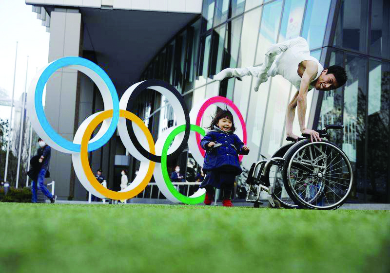 Kenta Kambara, 34, poses for a photo while his daughter Shiori, 2, walks past him, next to an Olympic Rings symbol in front of the Japan Olympic Museum in Tokyo, Japan, February 22, 2020. REUTERS/Kim Kyung-Hoon