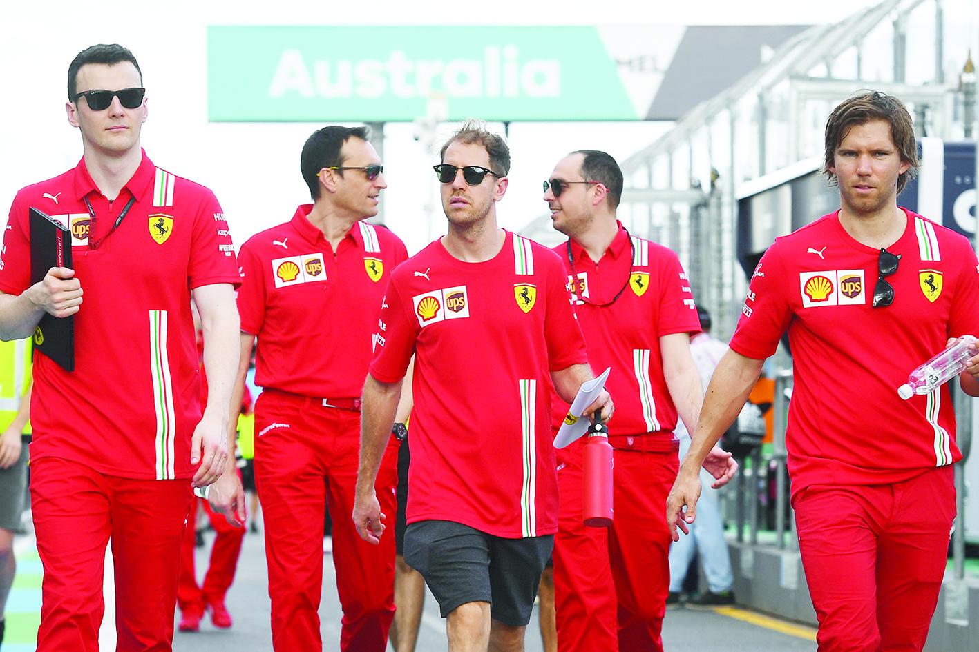 Ferrari's German driver Sebastian Vettel (C) walks down pit lane with team members at the Albert Park circuit ahead of the Formula One Australian Grand Prix in Melbourne on March 11, 2020. (Photo by William WEST / AFP) / -- IMAGE RESTRICTED TO EDITORIAL USE - STRICTLY NO COMMERCIAL USE --