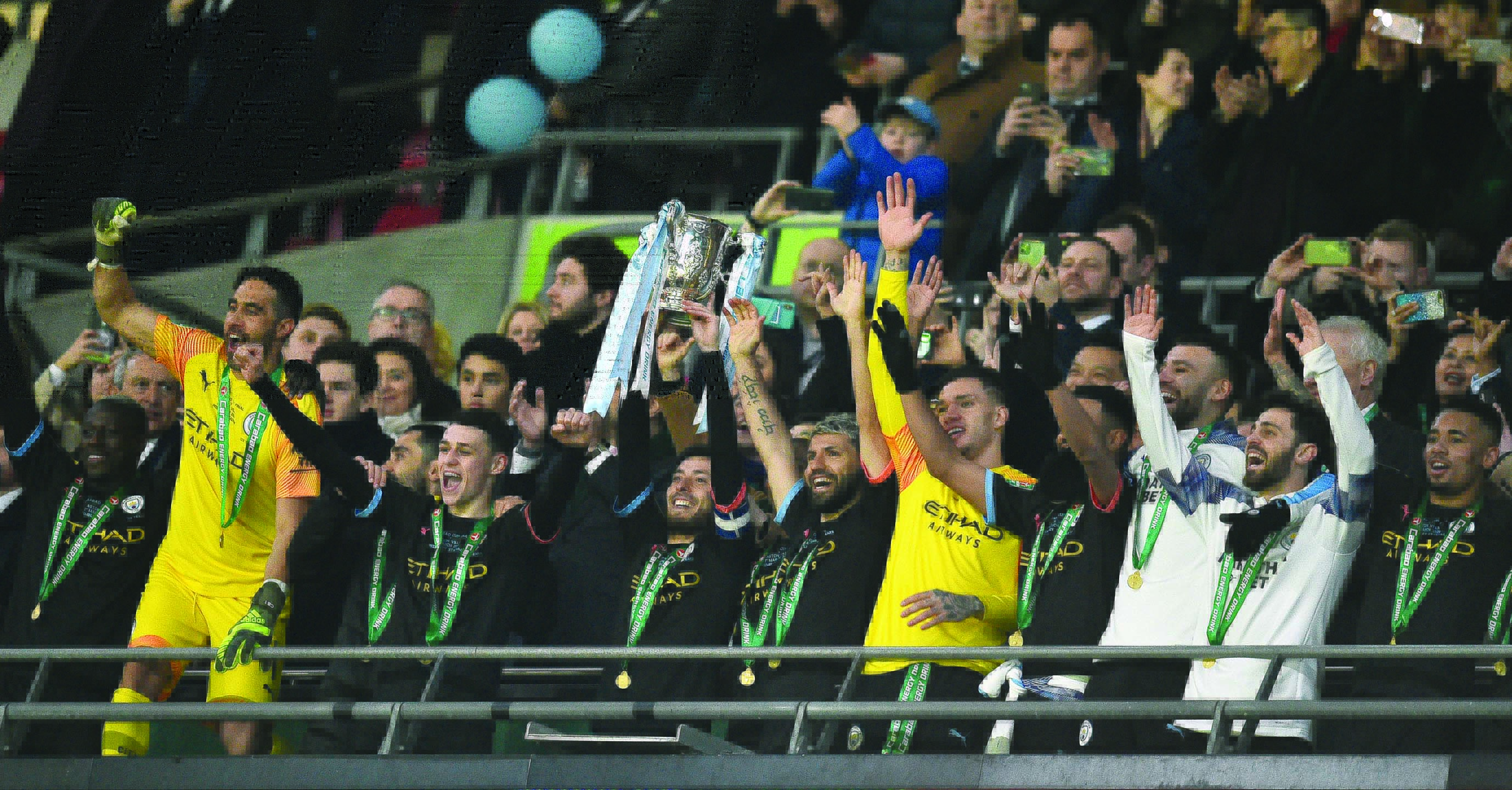 Manchester City captain David Silva lifts the trophy as his teammates celebrate their win after the English League Cup final football match between Aston Villa and Manchester City at Wembley stadium in London on March 1, 2020. - Manchester City won the game 2-1. (Photo by Glyn KIRK / AFP)