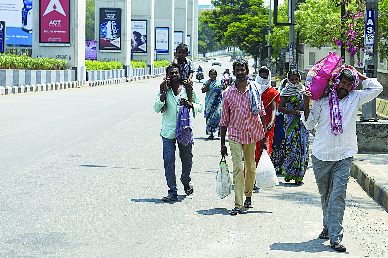 Migrant workers and their family members walk along a deserted road as they leave the city for their village during a government-imposed nationwide lockdown as a preventive measure against the spread of the COVID-19 novel coronavirus in Hyderabad on March 30, 2020. (Photo by Noah SEELAM / AFP)