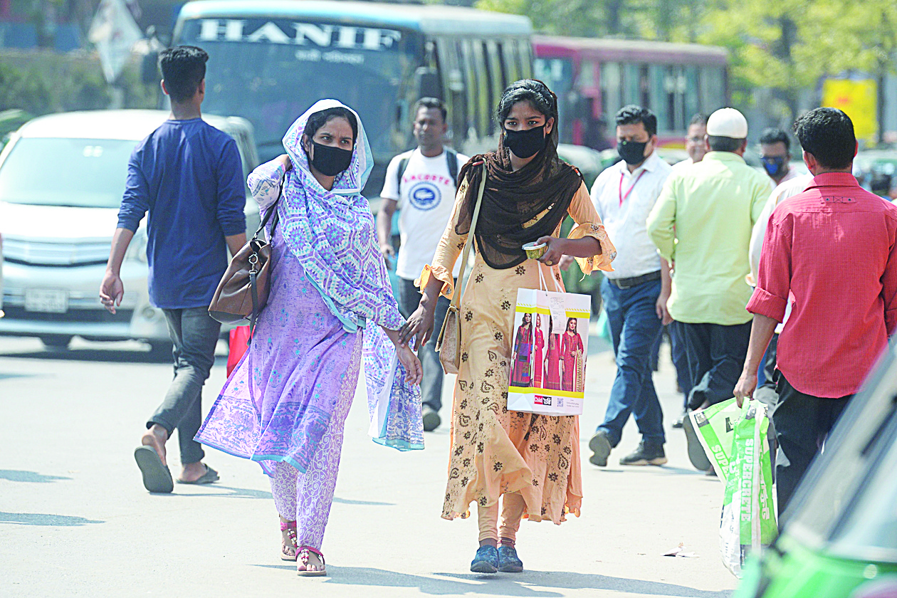 Women wearing facemasks amid fears of the spread of COVID-19 novel coronavirus, walk through a street, in Dhaka on March 9, 2020. (Photo by Munir UZ ZAMAN / AFP)