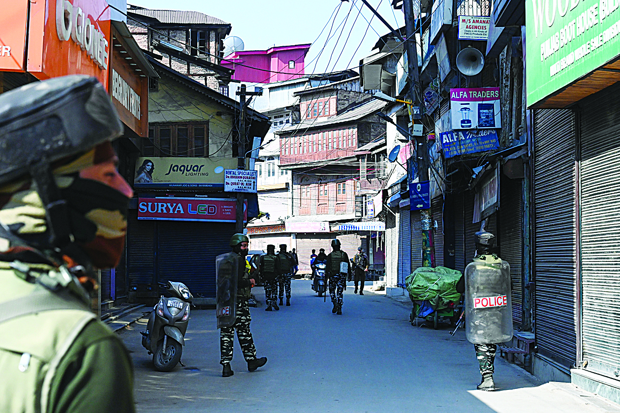 Soldiers patrol along an alleyway with closed shops following restrictions imposed as a preventive measure against the COVID-19 coronavirus in Srinagar on March 19, 2020. (Photo by Tauseef MUSTAFA / AFP)