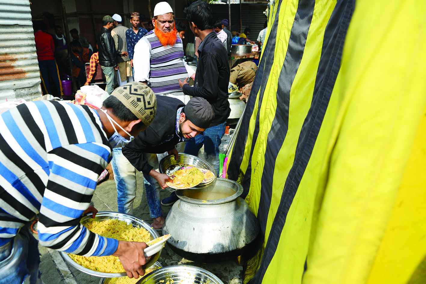 Volunteers serves food for displaced people of last week's sectarian riots in India's capital over the controversial citizenship law, at Eidgah Masjid in Mustafabad area of New Delhi on March 5, 2020. (Photo by Sajjad HUSSAIN / AFP)