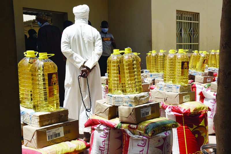 A man stands between food parcels during the launch of the distribution of food in the courtyard of the community hotel in Yene on April 28, 2020. - Senegal on April 28, 2020, kicked off a massive food distribution operation to help nearly half of its population cope with the consequences of the Covid-19 pandemic, which is slowing down the economy of this West African country. (Photo by Seyllou / AFP)