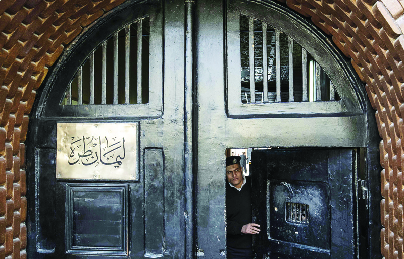 (FILES) In this file photo taken during a guided tour organised by Egypt's State Information Service on February 11, 2020, an Egyptian police officer stands at the entrance of the Tora prison in the Egyptian capital Cairo. - As governments in the Middle East isolate their populations to prevent the spread of coronavirus, attention is turning the region's jails where detainees face a more punishing form of lockdown. Some Middle Eastern governments have released prisoners as part of their response to the novel coronavirus pandemic, while others have ignored pressure to do so. (Photo by Khaled DESOUKI / AFP)
