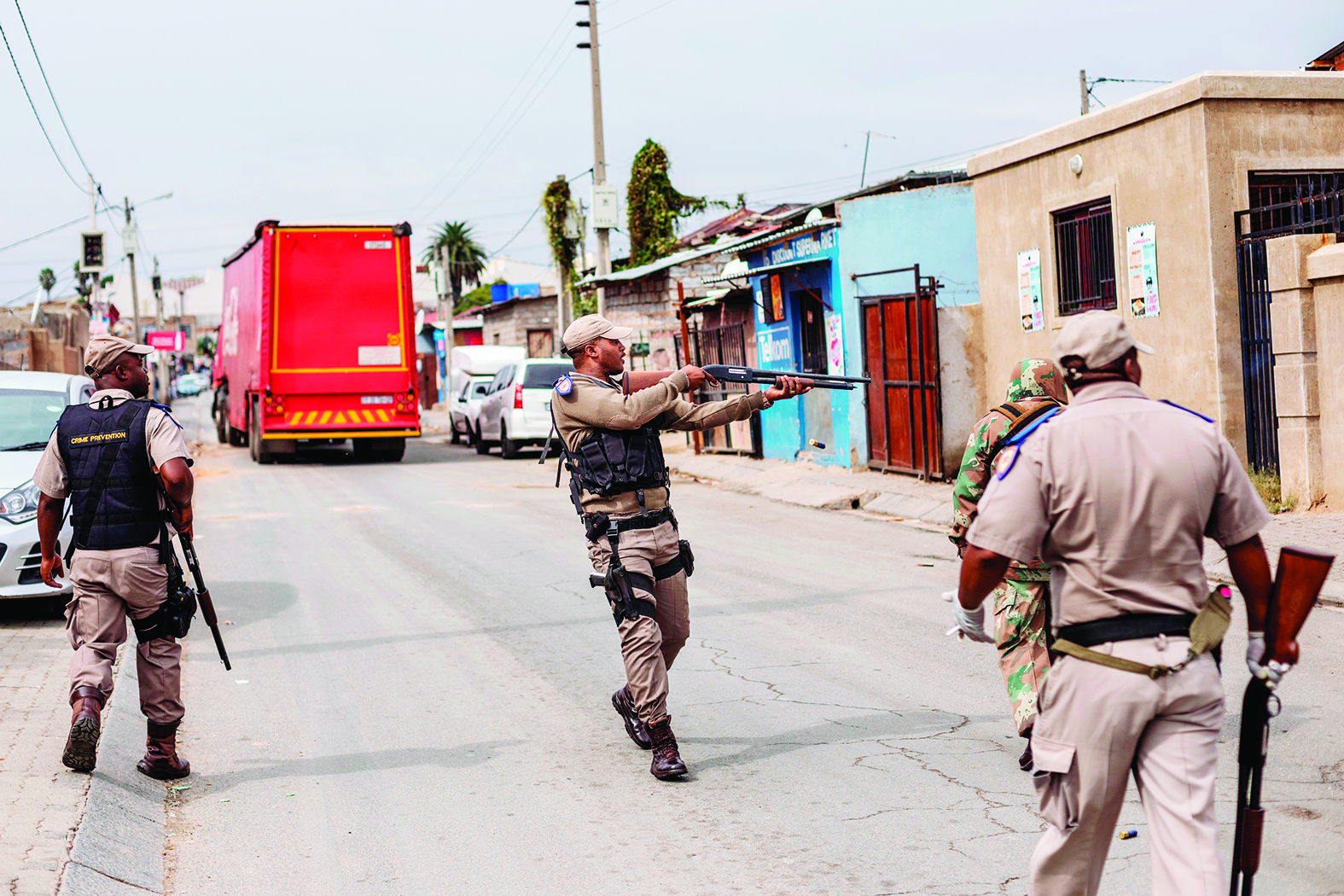 A Gauteng Traffic Police officer fires rubber bullets to urge residents to get inside during a mixed patrol of South African National Defence Force (SANDF) and Gauteng Traffic Police in Alexandra, Johannesburg, on March 31, 2020. - South Africa came under a nationwide lockdown on March 27, 2020, joining other African countries imposing strict curfews and shutdowns in an attempt to halt the spread of the COVID-19 coronavirus across the continent. (Photo by Michele Spatari / AFP)