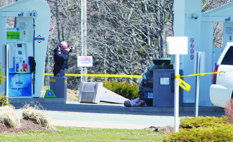 EDITORS NOTE: Graphic content / A member of the Royal Canadian Mounted Police (RCMP) forensic identification unit photographs the body of a deceased man after a deadly shooting rampage, at the Big Stop near Elmsdale, Nova Scotia, Canada, on April 19, 2020. - A gunman killed at least 10 people in an overnight shooting rampage across rural Nova Scotia, before being found dead following an hours-long manhunt, Canadian federal police said April 19. Earlier identified as 51-year-old Gabriel Wortman, the suspect had been on the run since Saturday night, when police were alerted to shots being fired in the small community of Portapique, around 100 kilometers (60 miles) from Halifax, capital of the Atlantic province. (Photo by Tim KROCHAK / AFP)