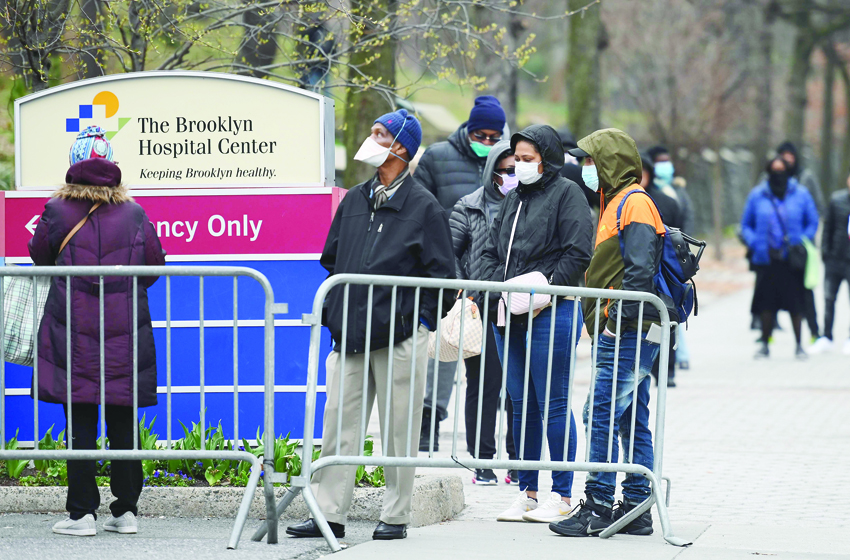 People who believe they have COVID-19, and who meet the criteria, wait in line to be pre-screened for the coronavirus outside of the Brooklyn Hospital Center on March 20, 2020 in the Brooklyn borough of New York. - The new coronavirus isn't picky about who it infects -- so why does data emerging from some states suggest that African Americans are bearing the brunt?nExperts say the community is disproportionately impacted by underlying conditions linked to poverty, and often faces challenges in accessing testing and health care (Photo by Angela Weiss / AFP)