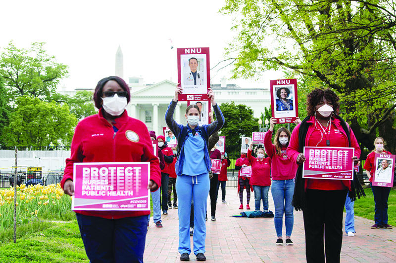 TOPSHOT - Nurses protest against the lack of personal protection equipment amid the covid-19 pandemic in front of the White House in Washington, DC, on April 21, 2020. (Photo by NICHOLAS KAMM / AFP)