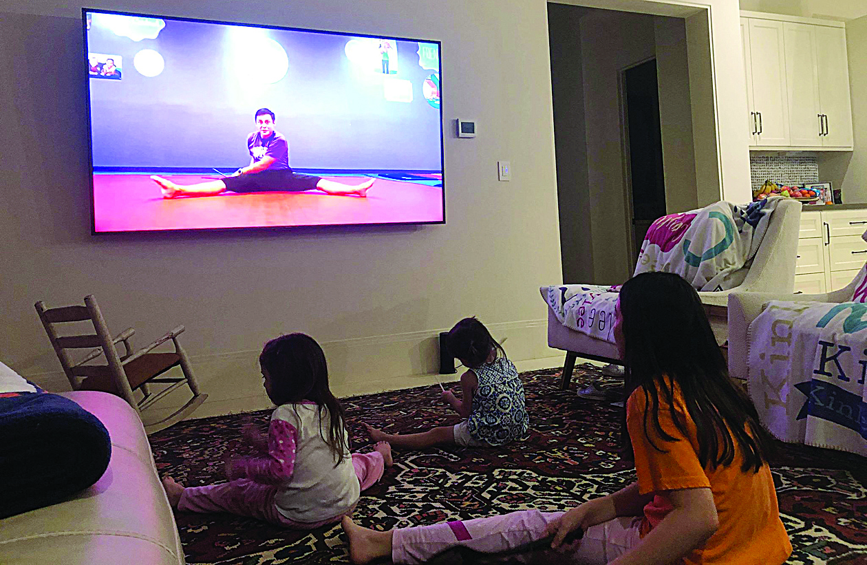 This family handout photo taken and released by Lauren Soliz shows (from R) Caylee, Kinley and Riley Canonico following an online Little Gym class from their living room in Houston, Texas on March 24, 2020. - Every afternoon since they started staying in their Texas home due to the coronavirus outbreak, the Canonico sisters -- ages two, four and 10 -- spend some time banging on pots and pans. It's not just idle play: they are taking online classes from a local kids' gym in Houston to burn up some of their pent-up energy -- and to learn crucial motor and social skills. (Photo by Lauren Soliz / FAMILY HANDOUT / AFP) /