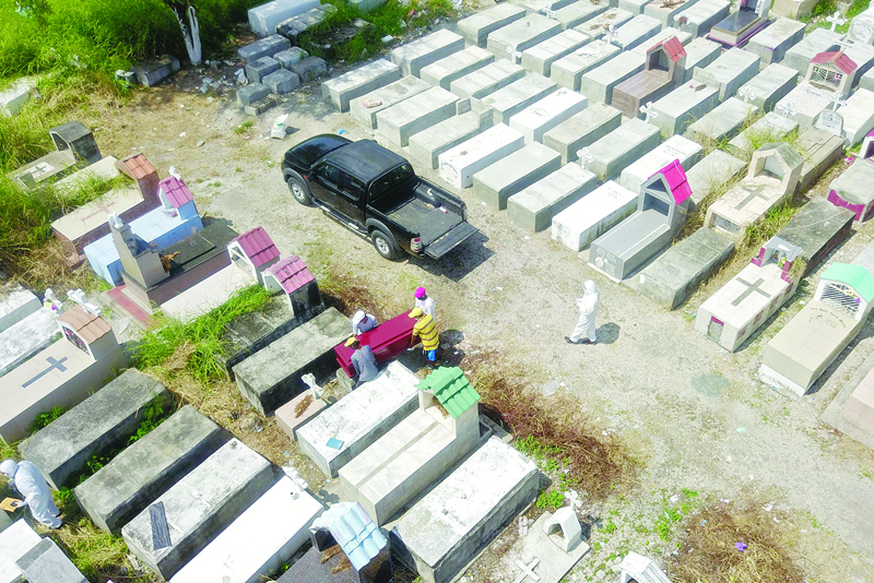 Aerial view of workers burying a coffin at Maria Canals cemetery in the outskirts of Guayaquil, Ecuador, on April 12, 2020. (Photo by Jose S·nchez / AFP)
