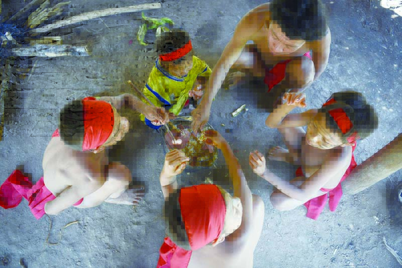 A Yanomami family eats at Irotatheri community, in Amazonas state, southern Venezuela, 19 km away from the border with Brazil, on September 7, 2012. The Venezuelan government on Friday agreed to lead a delegation of national and international media to Irotatheri after a slaughter of 80 Yanomami natives was reported. Venezuelan militarymen detected evidence of illegal mining in the south of the country, where Yanomami natives would have presumably been massacred by Brazilian illegal gold prospectors.  AFP PHOTO/Leo RAMIREZ (Photo by LEO RAMIREZ / AFP)