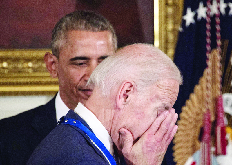 (FILES) In this file photo taken on January 12, 2017, US Vice President Joe Biden wipes away tears as he walks past President Barack Obama after he was awarded the Presidential Medal of Freedom during a tribute to Biden at the White House in Washington, DC. - Former US President Barack Obama is set to endorse Biden as a the Democratic nominee running against US President Donald Trump, sources close to ex-president said on April 14, 2020. (Photo by NICHOLAS KAMM / AFP)