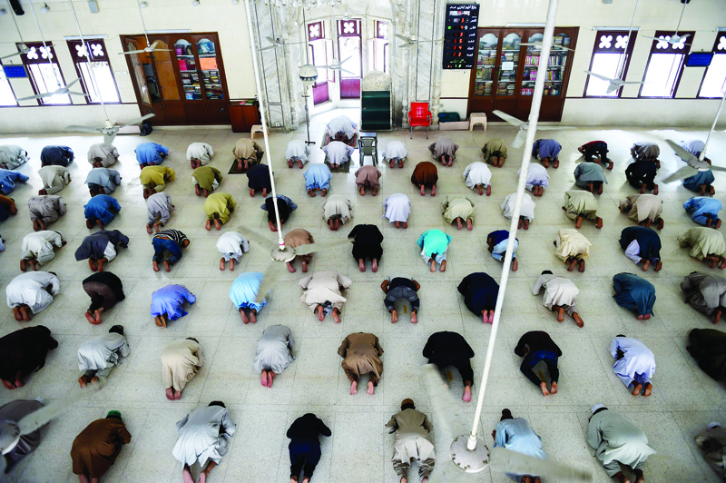 TOPSHOT - In this picture taken on April 19, 2020, Muslims maintain social distancing during noon prayers at a mosque in Karachi during a government-imposed nationwide lockdown as a preventive measure against the COVID-19 coronavirus. - Across the continent, home to about half of the world's Muslims, the upcoming Islamic holy month of Ramadan is on a collision course with the coronavirus. (Photo by Rizwan TABASSUM / AFP) / To go with AFP story Health-virus-Asia-Muslim-Ramadan-religion, FOCUS by David Stout and Sajjad Tarakzai