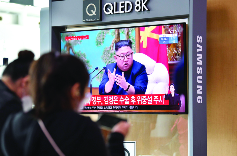 People watch a television news broadcast showing file footage of North Korean leader Kim Jong Un, at a railway station in Seoul on April 21, 2020. - South Korea played down a report on April 21 that the North's leader Kim Jong Un was being treated after surgery, as speculation mounted over his absence from a key anniversary. (Photo by Jung Yeon-je / AFP)