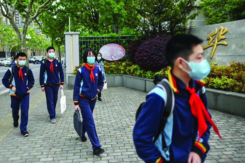Students wearing face masks arrive at the Huayu Middle School in Shanghai on April 27, 2020. - Students returned to class on April 27 for the first time since schools were closed down in January as part of efforts to stop the spread of the COVID-19 coronavirus. (Photo by Hector RETAMAL / AFP)
