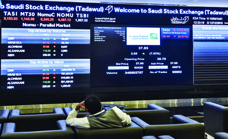 (FILES) A file photo taken on December 12, 2019 shows a man watching the exchange board at the Stock Exchange Market (Tadawul) bourse in the Saudi capital Riyadh. - The Saudi stock market opened down 2.1 percent on April 21, 2020 leading a dip on Gulf markets after US oil prices slumped to historic lows. The Dubai Financial Market also dropped, by 2.6 percent, after oil traded in negative territory. All the Gulf states depend on oil income for most of their public revenues. (Photo by FAYEZ NURELDINE / AFP)