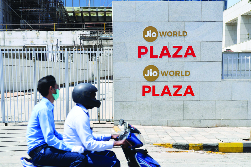 Motorists ride past the Jio World Centre during a government-imposed nationwide lockdown as a preventive measure against the spread of the COVID-19 coronavirus, in Navi Mumbai on April 22, 2020. - Facebook has taken a $5.7 billion stake in the Jio digital platforms business of India's richest man Mukesh Ambani, the two sides said on April 22, marking one of the biggest foreign investments in the country. The deal will give the US social media giant a 10 percent stake in Jio Platforms, part of Ambani's Reliance Industries empire. (Photo by INDRANIL MUKHERJEE / AFP)
