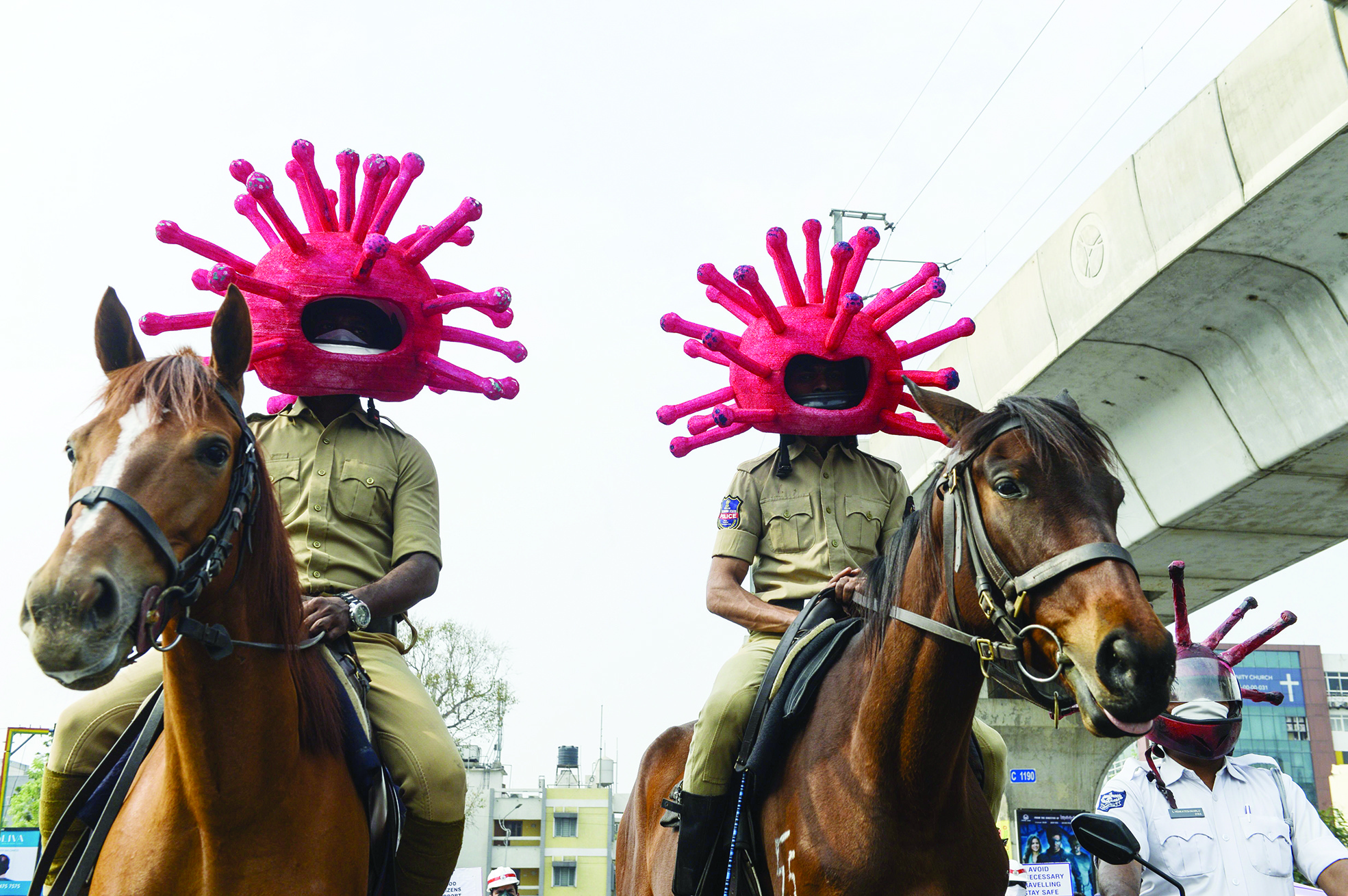 TOPSHOT - Police personnel wearing coronavirus-themed helmets ride on horses as they participate in a awareness campaign during a 21-day government-imposed nationwide lockdown as a preventive measure against the COVID-19 coronavirus in Secunderabad, the twin city of Hyderabad, on April 2, 2020. (Photo by NOAH SEELAM / AFP)