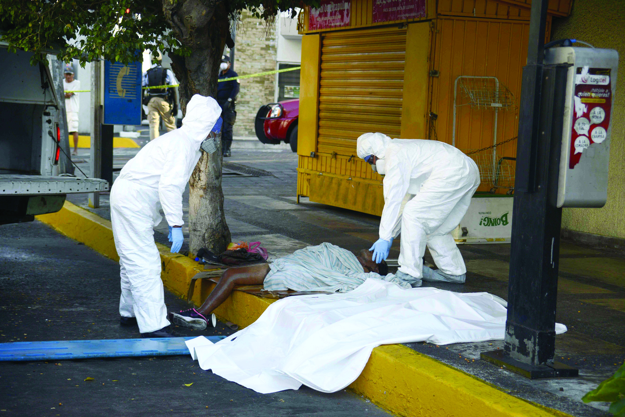 TOPSHOT - EDITORS NOTE: Graphic content / A corpse of a homeless man, suspected of having the COVID-19 coronavirus, is removed by forensic workers in Acapulco, Mexico, on April 23, 2020. (Photo by FRANCISCO ROBLES / AFP)