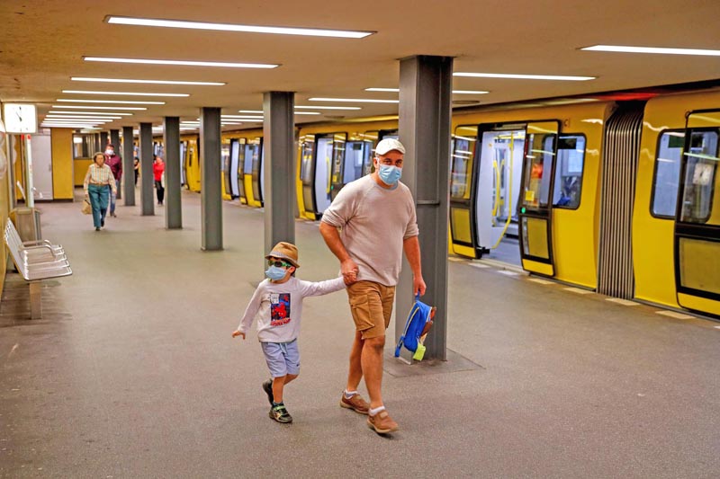 People wear face protection masks at the Bahnhof Zoo subway station in Berlin on April 27, 2020 in Berlin, amid the new coronavirus COVID-19 pandemic. - Protective masks will be required on public transport in most parts of Germany, with capital Berlin joining on April 27, 2020 a wave of federal states in ordering the measure to stem contagion of the novel coronavirus. (Photo by Odd ANDERSEN / AFP)