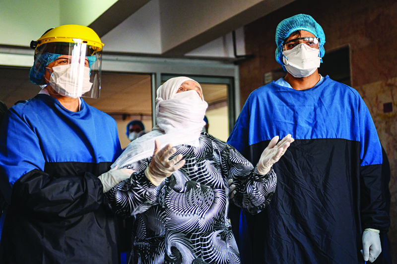 Medical staff cheer as Alye Gunduz (C), 93 years old, who was treated for Covid-19 (novel coronavirus) is escorted to be discharged from the Istanbul University Cerrahpasa medical faculty Hospital after ten days of treatment on April 10, 2020 in Istanbul. - The Cerrahpasa Medical Faculty has responded fast since the outbreak in mid March, turning its operating theatres into intensive care units and creating special pandemic sections separating ordinary patients from others infected with coronavirus -- where entries and exists to and from which are prohibited. (Photo by Ozan KOSE / AFP)