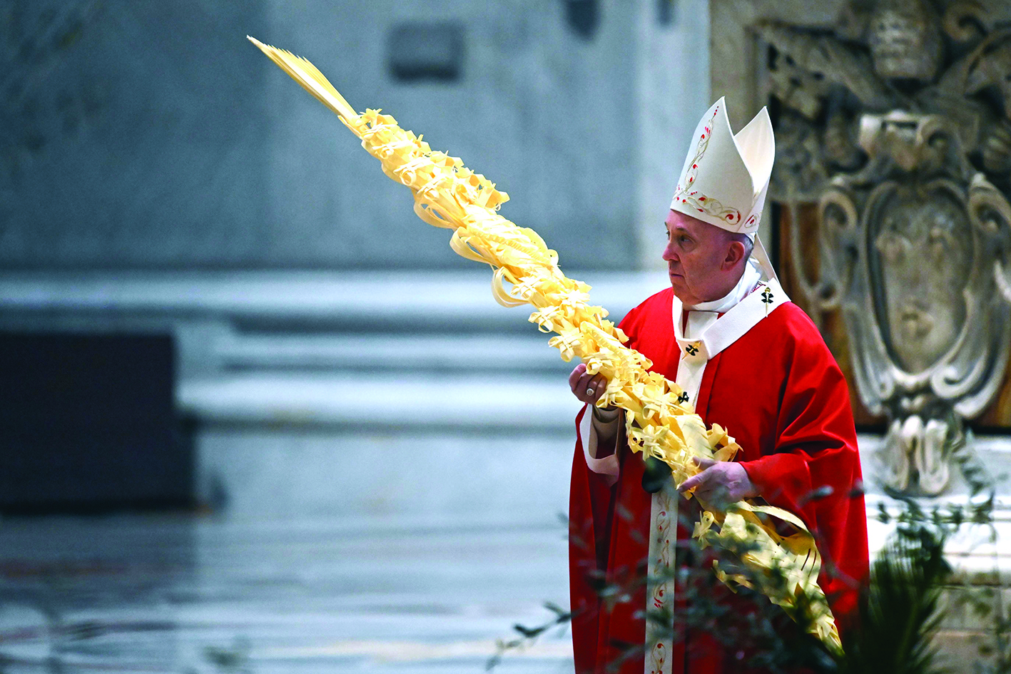 Pope Francis holds a palm branch as he celebrates Palm Sunday mass behind closed doors at St. Peter's Basilica mass on April 5, 2020 in The Vatican, during the lockdown aimed at curbing the spread of the COVID-19 infection, caused by the novel coronavirus. (Photo by Alberto PIZZOLI / POOL / AFP)
