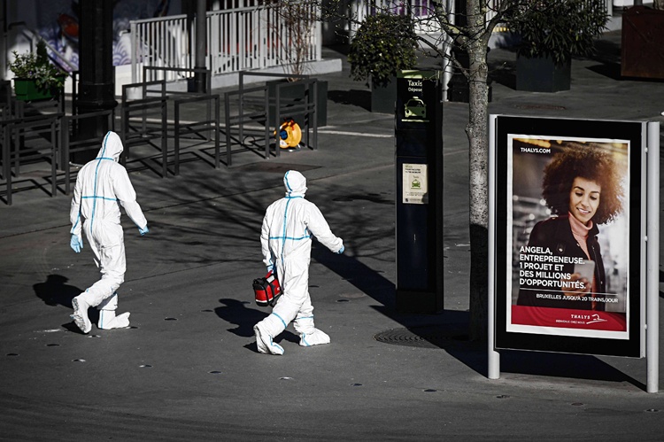 Medical personnel wearing protective gear outside the Gare d'Austerlitz rail station in Paris, on April 5, 2020, during an evacuation operation of patients infected with COVID-19 onboard a TGV high speed train, on the on the 20th day of a lockdown in France aimed at curbing the spread of COVID-19 (novel coronavirus). - France has been evacuating COVID-19 patients from packed hospitals in hard-hit regions to hospitals is less affected regions of the country by transporting them in medically equipped TGV high speed trains. (Photo by Philippe LOPEZ / AFP)
