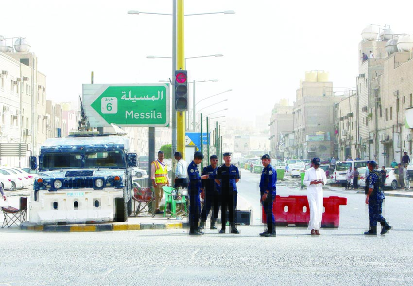 Kuwaiti police officers man a checkpoint at the entrance the town of Jeleeb Al-Shuyoukh, south the capital Kuwait City on April 7, 2020, after the district was put on lockdown. (Photo by YASSER AL-ZAYYAT / AFP)