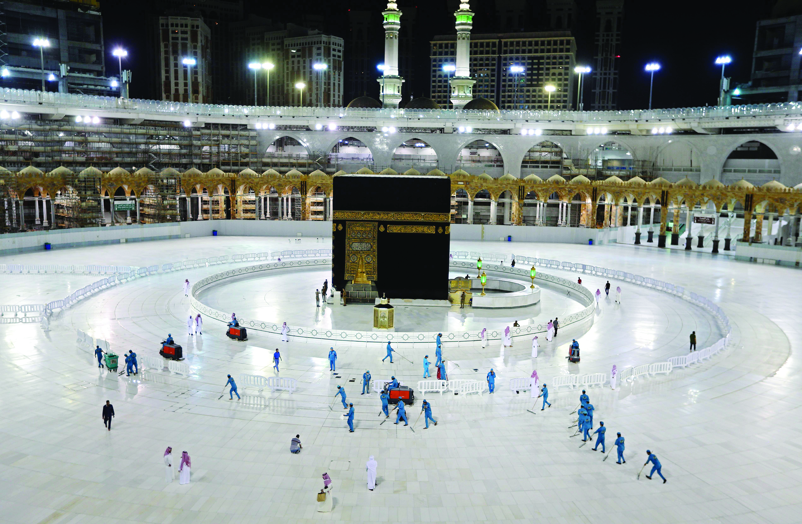 TOPSHOT - A picture taken on April 24, 2020, shows sanitation workers disinfection the area arround the Kaaba in Mecca's Grand Mosque, on the first day of the Islamic holy month of Ramadan, amid unprecedented bans on family gatherings and mass prayers due to the coronavirus (COVID-19) pandemic. (Photo by STR / AFP)