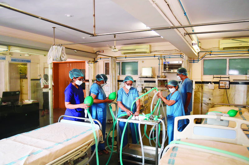 Doctors and nursing staff test a four way multiplexer machine, which splits oxygen supply from a single ventilator to four patients through inspiratory limbs simultaneously,  during a government-imposed nationwide lockdown as a preventive measure against the COVID-19 coronavirus, at the Institute of Kidney Diseases and Research Centre (IKDRC) in Ahmedabad on April 20, 2020. (Photo by SAM PANTHAKY / AFP)