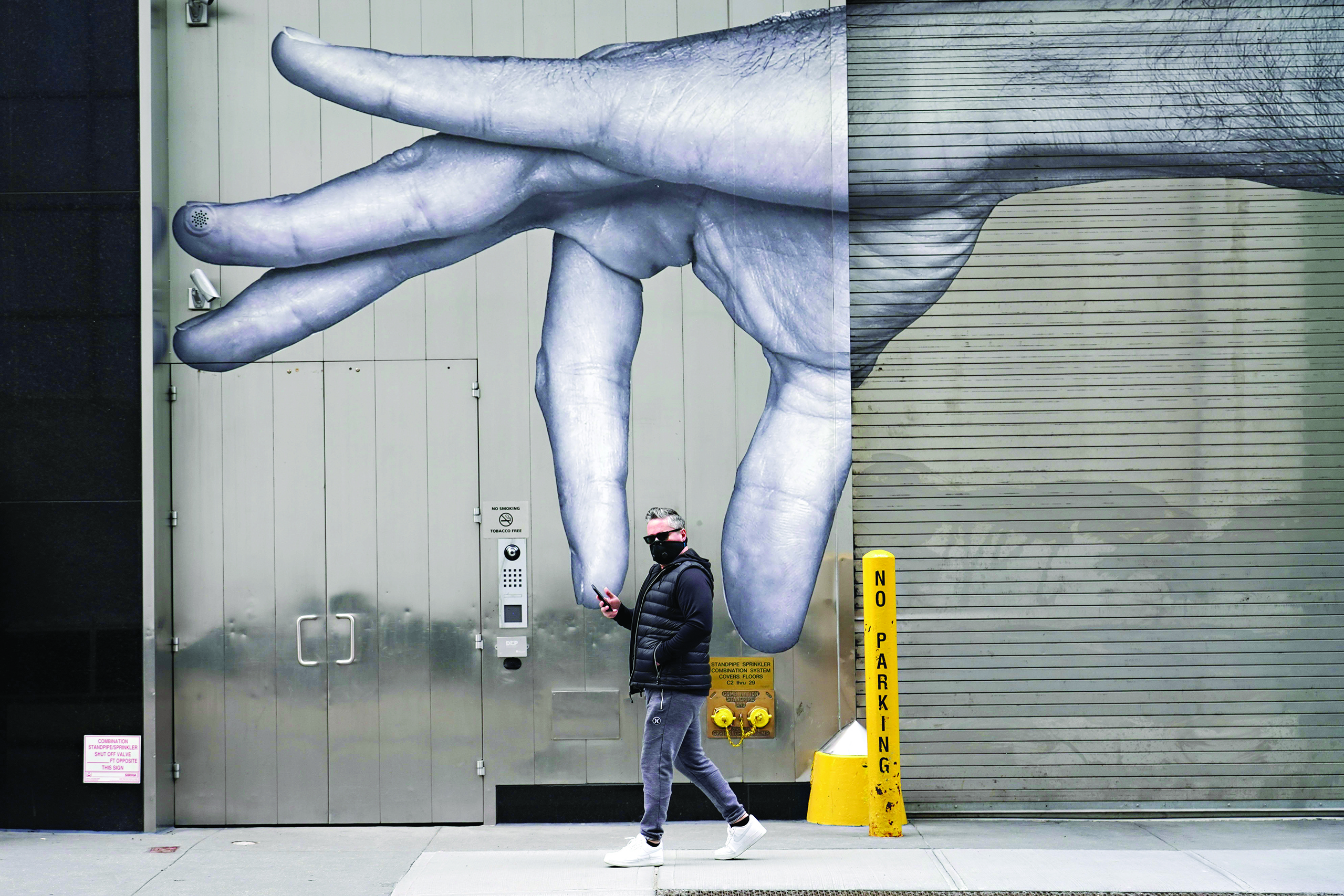 NEW YORK, NEW YORK - APRIL 05: A man wearing a protective mask walks by street art amid the coronavirus pandemic on April 05, 2020 in New York City. COVID-19 has spread to most countries around the world, claiming almost 70,000 lives with infections nearing 1.3 million people.   Cindy Ord/Getty Images/AFPn== FOR NEWSPAPERS, INTERNET, TELCOS &amp; TELEVISION USE ONLY ==