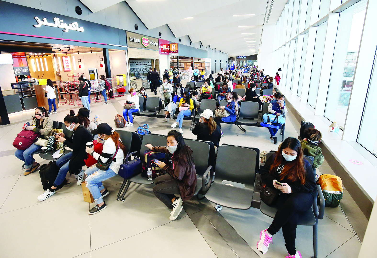 Filipinos who availed general amnesty granted by the Kuwaiti government are pictured gathering at the Kuwait International Airport Terminal 4, on April 3, 2020 on their home to Manila amid the coronavirus COVID-19 pandemic crisis. - For systematic documentations, illegal expats from the Philippines, Egypt, India, Bangladesh, Sri Lanka and other countries  were at first, requested to submit themselves at a school compound in Farwaniya arranged according to nationalities. (Photo by YASSER AL-ZAYYAT / AFP)