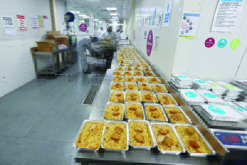 Qatar charity workers prepare food parcels for migrant labourers living under quarantine on April 16, 2020 amid the coronavirus COVID-19 pandemic in Doha. (Photo by KARIM JAAFAR / AFP)