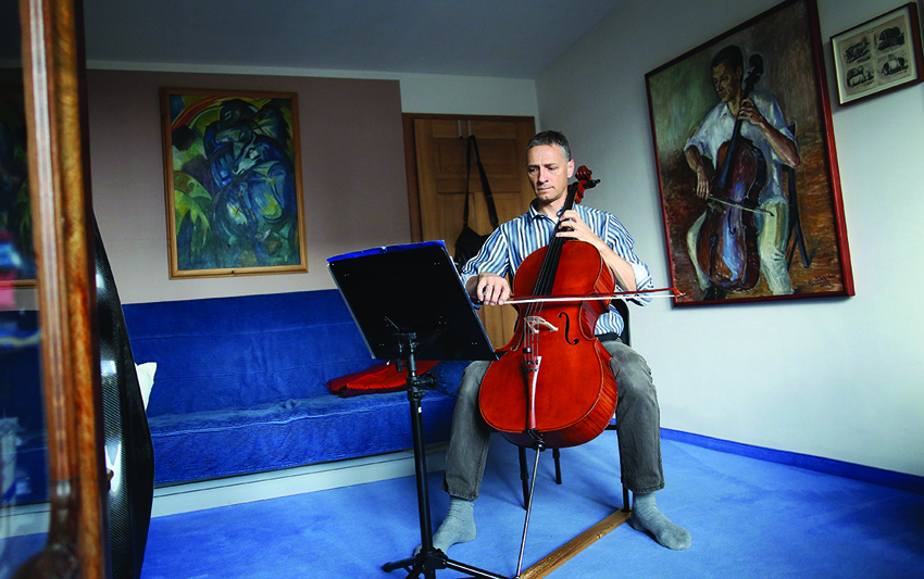 German musician Stephan Wuensch, principal cellist of the Musical Comedy of Leipzig Opera, plays the violoncello at home, where he stays confined due to the pandemic of the novel coronavirus, on April 3, 2020 on the outskirts of Leipzig, eastern Germany. - The gates of the Leipzig Opera have been closed for about three weeks due to the novel corona pandemic - but the voices and instruments of the artists are far from silent. (Photo by Ronny Hartmann / AFP)