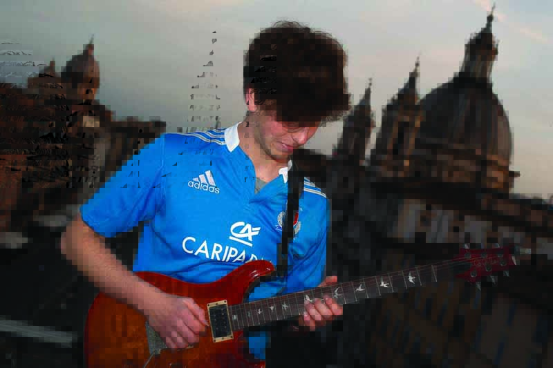 Jacopo Mastrangelo plays the guitar from his terrace overlooking Piazza Navona in Rome  on April 16, 2020, during a lockdown in Italy to curb the spread of the COVID-19 pandemic, caused by the new coronavirus. (Photo by Tiziana FABI / AFP)