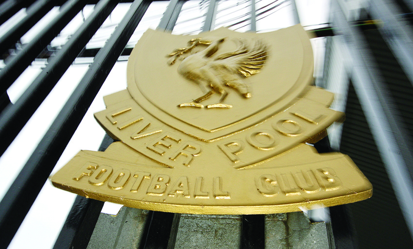 (FILES) In this file photo taken on January 16, 2007 The Liverpool football club emblem is pictured on a gate at the Anfield ground in Liverpool, north-west England. - Liverpool Football Club announced late on April 6, 2020, that they had reversed their earlier decision to place some non-playing staff on temporary leave during the COVID-19 pandemic, or 'Furlough' them, by applying to the British government for funds to pay for up to 80 percent of their wages, and apologised to fans. (Photo by PAUL ELLIS / AFP)