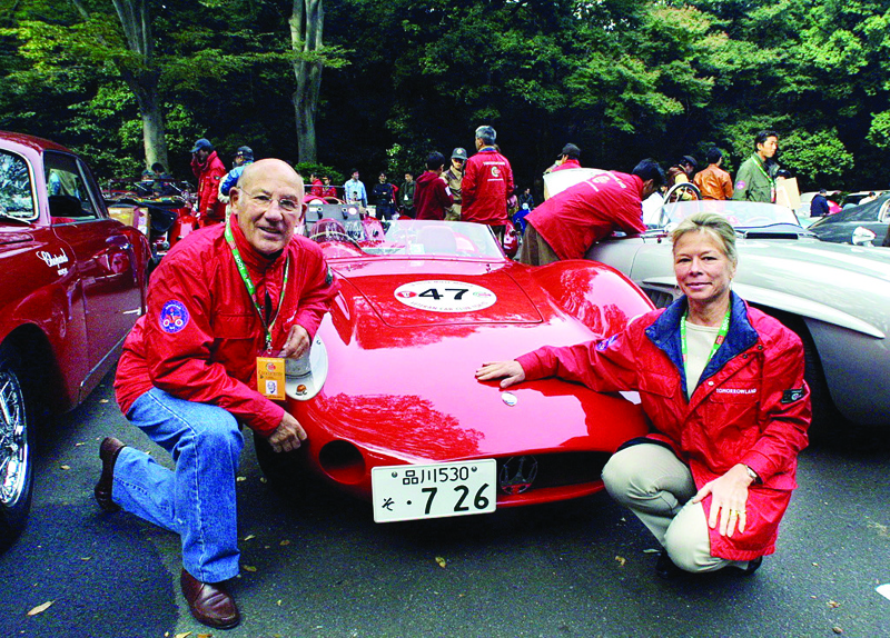(FILES) In this file photo taken on October 22, 2001 British motor-racing legend Stirling Moss (L) and his wife Susie Moss (R) pose beside their 1957 Maserati 200 Si prior to start the vintage car rally festival, La Festa Mille Miglia 2001 in Tokyo. - Motorsport great Stirling Moss has died aged 90 following a long illness, the British driver's wife announced Sunday, April 12. (Photo by TOSHIFUMI KITAMURA / AFP)