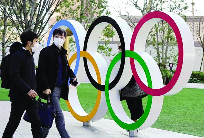 epa08251597 Visitors wearing face masks walk past the Olympic Rings monument in front of the Japan Olympic Committee headquarters near the new National Stadium, venue of the Opening and Closing Ceremony of the Tokyo 2020 Summer Olympic Games, in Tokyo, Japan, 27 February 2020. Preparations for the Tokyo 2020 Olympic Games, scheduled to start on 24 July 2020, continue as planned despite the spreading Covid-19 coronavirus outbreak, organizers confirmed.  EPA-EFE/KIMIMASA MAYAMA