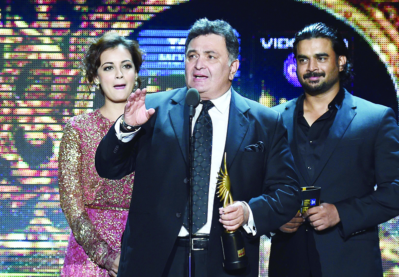 (FILES) In this file photo taken on April 27, 2014 Bollywood actor Rishi Kapoor (C) receives the award for Best performance in a Negative Role during the fourth and final day of the 15th International Indian Film Academy (IIFA) Awards at the Raymond James Stadium in Tampa, Florida. - Bollywood mourned its second loss in as many days as celebrated actor Rishi Kapoor, whose career spanned half a century, died April 30, 2020, aged 67 after a prolonged struggle with cancer. His death came as a severe blow to the Hindi movie industry and film lovers, who were already reeling from the death of Irrfan Khan, one of the country's most feted actors, on April 29 aged just 53. (Photo by Jewel SAMAD / AFP)