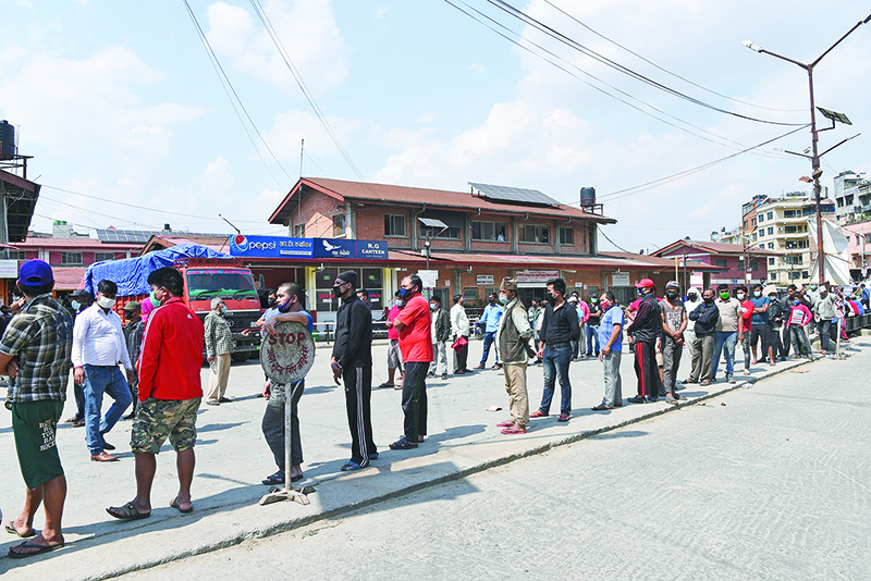 People stand in queues as they wait to be tested for a coronavirus test at Kalimati vegetable market during a government-imposed nationwide lockdown as a preventive measure against the spread of the COVID-19 coronavirus, in Kathmandu on May 14, 2020. (Photo by PRAKASH MATHEMA / AFP)