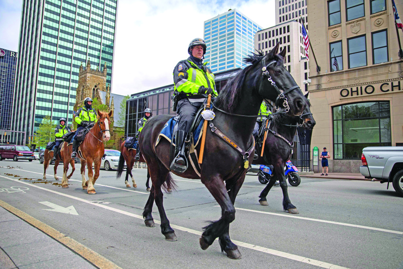Police officers on horses patrol as demonstrators protest outside the Ohio statehouse in opposition of Governor DeWine's stay-at-home order in Columbus, Ohio on May 1, 2020. (Photo by Brad LEE / AFP)