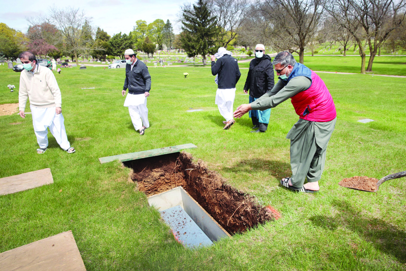 ELGIN, ILLINOIS - MAY 04: Mourners bury the remains of Ghulam Farid at Bluff City Cemetery following a funeral service at Masjid Al Huda (also know as the Midwest Islamic Center) on May 04, 2020 in Elgin, Illinois. According to funeral director Rezwan Haque, funerals held at Masjid Al Huda typically draw 150 to 500 mourners but, because of the coronavirus pandemic, families are informed that they are limited to 10. Farid's death was not attributed to COVID-19.   Scott Olson/Getty Images/AFPn== FOR NEWSPAPERS, INTERNET, TELCOS &amp; TELEVISION USE ONLY ==
