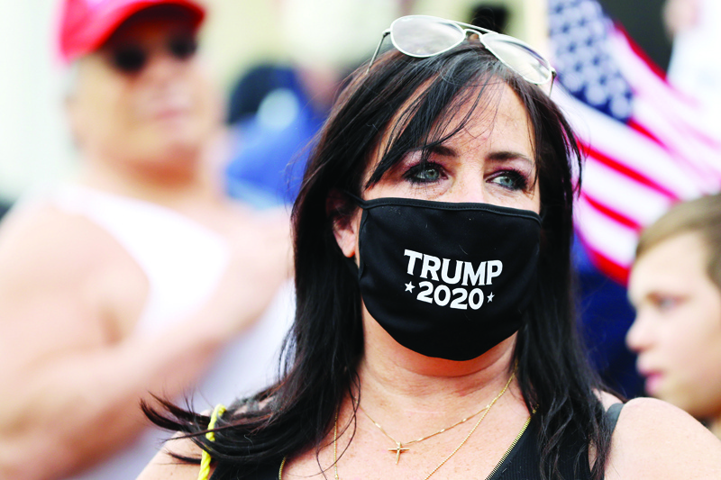 BOSTON, MASSACHUSETTS - MAY 04: A protestor wears a Trump 2020 face mask during a Reopen Massachusetts Rally outside of the Massachusetts State House on May 04, 2020 in Boston, Massachusetts. The coronavirus (COVID-19) pandemic has caused caused closure of all non-essential businesses in the state since March 23. Over 60,000 people have tested positive for COVID-19 in Massachusetts.   Maddie Meyer/Getty Images/AFPn== FOR NEWSPAPERS, INTERNET, TELCOS &amp; TELEVISION USE ONLY ==