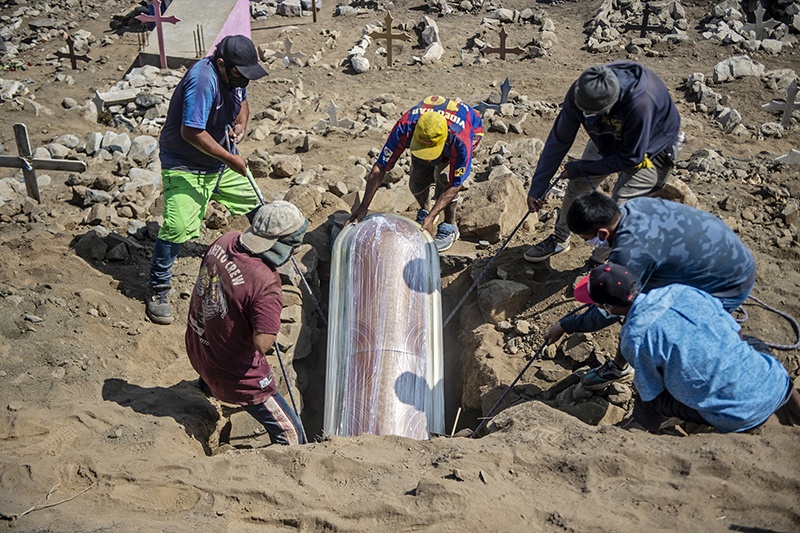 LIMA: Relatives bury the coffin of a suspected COVID-19 victim at the Nueva Esperanza cemetery, one of the largest in Latin America, in the southern outskirts of Lima. — AFP