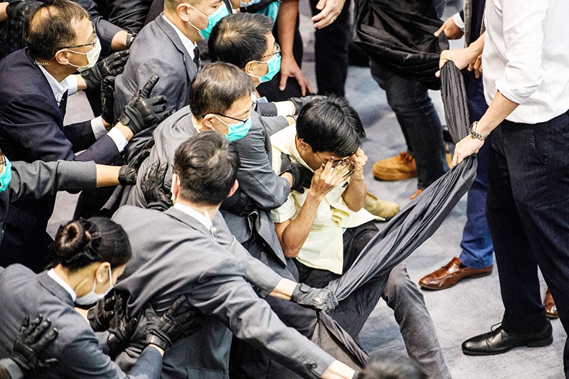 HONG KONG: Pro democracy lawmaker Eddie Chu (centre right) is surrounded by security during a scuffle with pro Beijing lawmakers at the House Committee’s election of chairpersons, presided by pro-Beijing lawmaker Chan Kin Por (not seen) at the Legislative Council in Hong Kong yesterday.- AFP