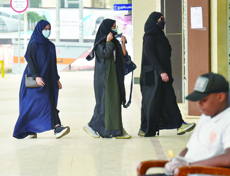 Saudi women, wearing protective face masks, walk into the Tiba gold market in the capital Riyadh on April 30, 2020, after the partial lifting of the curfew. (Photo by FAYEZ NURELDINE / AFP)