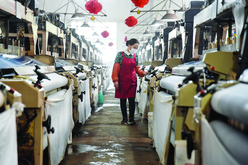 This photo taken on April 29, 2020 shows an employee working at a textile factory in Handan in China's northern Hebei province. - Chinese factory activity continued to expand in April, data showed on April 30, but analysts warned that the outlook remained clouded by battered overseas demand as the rest of the world struggles to overcome the coronavirus pandemic. (Photo by STR / AFP) / China OUT